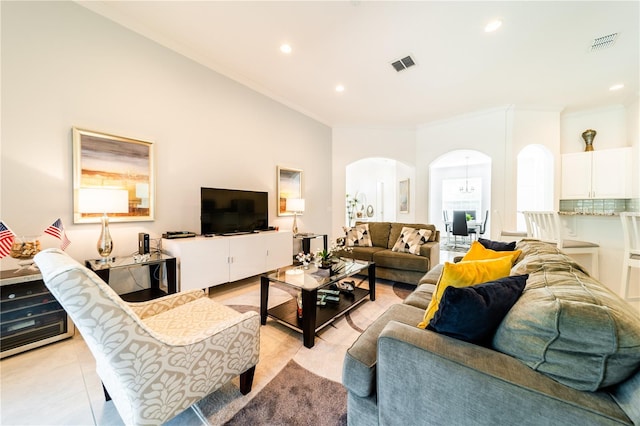 tiled living room featuring crown molding and a high ceiling