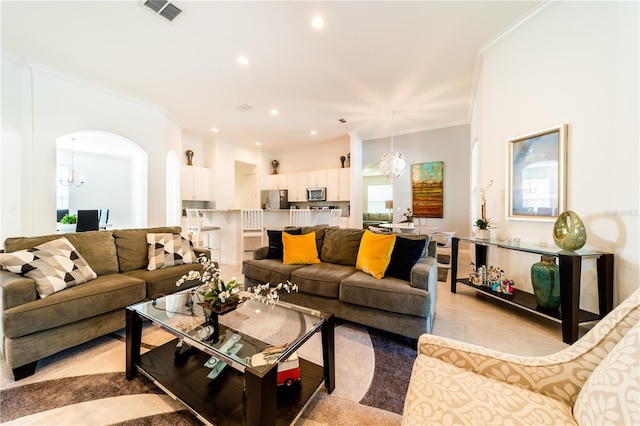 tiled living room featuring crown molding and an inviting chandelier