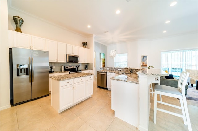 kitchen featuring sink, a center island with sink, hanging light fixtures, and appliances with stainless steel finishes