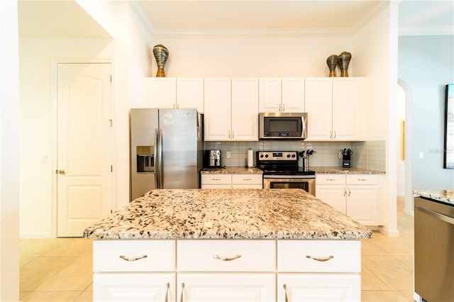 kitchen with tasteful backsplash, white cabinetry, a kitchen island, and appliances with stainless steel finishes