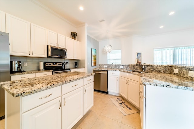 kitchen with a center island, sink, light tile patterned floors, white cabinetry, and stainless steel appliances