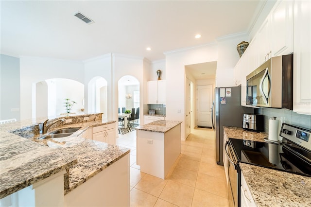 kitchen featuring a center island with sink, sink, light tile patterned flooring, light stone counters, and stainless steel appliances