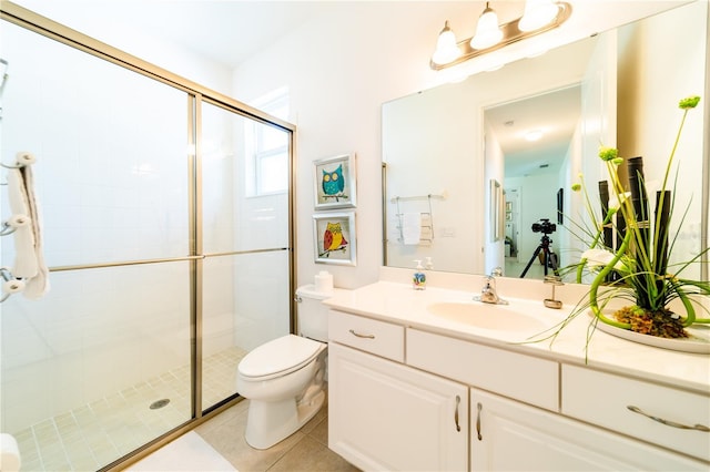 bathroom with toilet, tile patterned flooring, vanity, and walk in shower