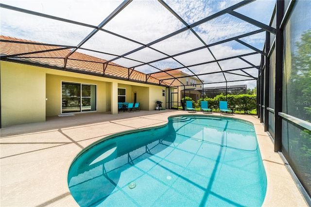 view of swimming pool featuring a patio area and a lanai