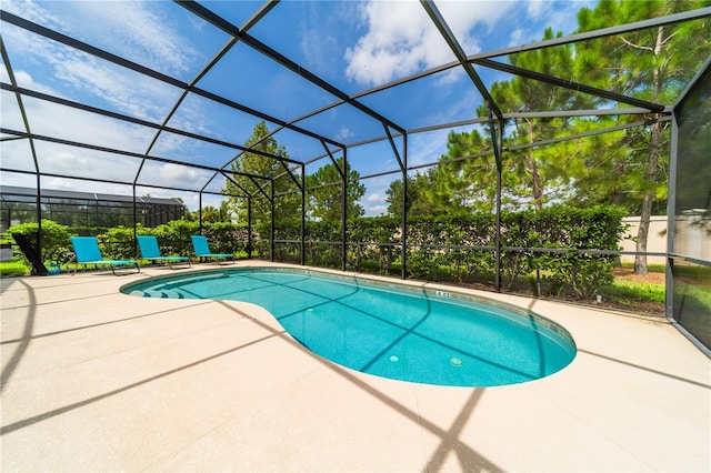 view of pool featuring glass enclosure and a patio area