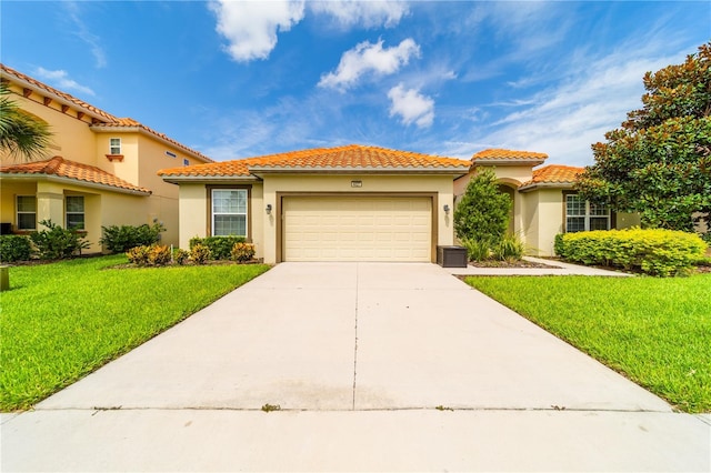 mediterranean / spanish house with a front lawn and a garage