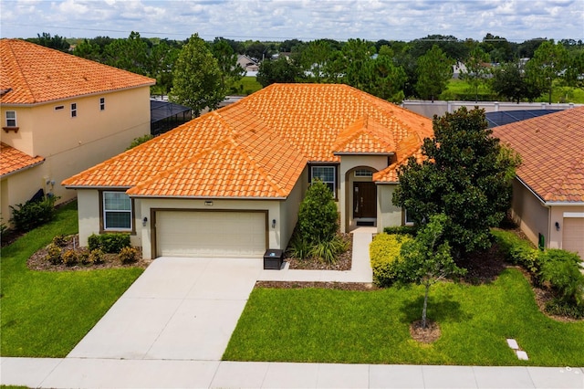 mediterranean / spanish-style house featuring a garage and a front lawn