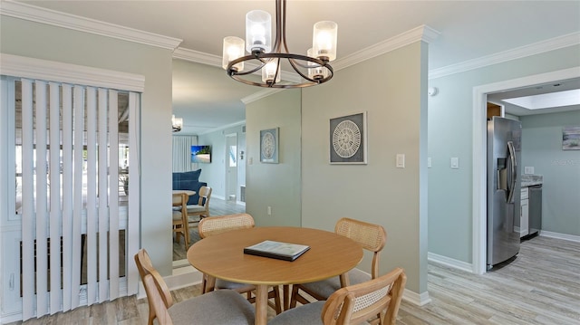 dining space with light hardwood / wood-style flooring, crown molding, and a notable chandelier