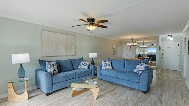 living room with ceiling fan with notable chandelier, light wood-type flooring, and ornamental molding