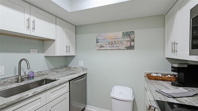 kitchen featuring dishwasher, light stone countertops, white cabinetry, and sink