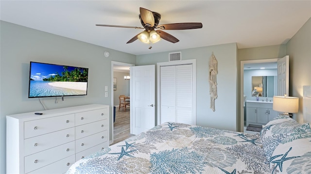 bedroom with ensuite bath, ceiling fan, a closet, and light hardwood / wood-style floors