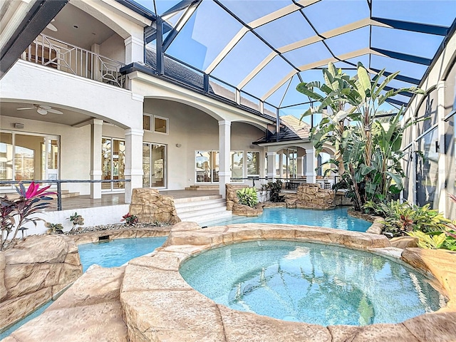 view of pool with a lanai, a patio area, an in ground hot tub, and ceiling fan