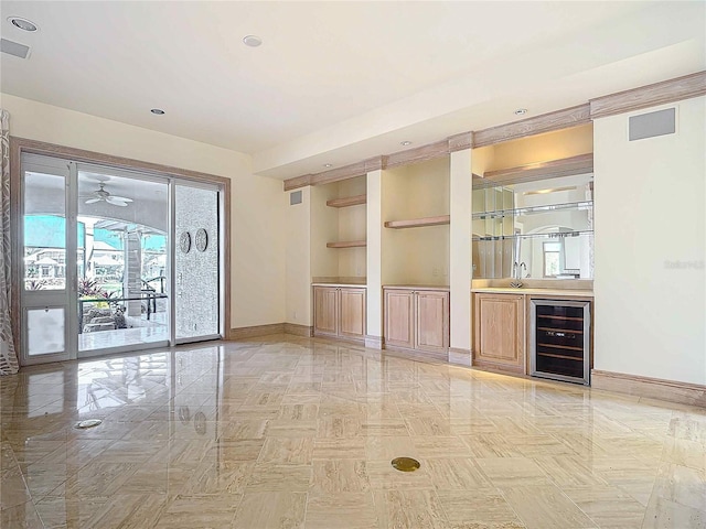 interior space featuring built in shelves, beverage cooler, and indoor bar