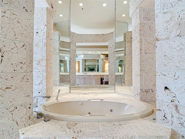 bathroom featuring vanity and tiled bath