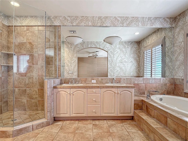 bathroom with ceiling fan, tile patterned flooring, separate shower and tub, vanity, and tile walls