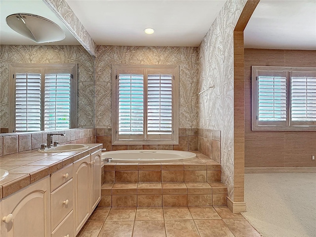 bathroom with tile patterned floors, vanity, and tiled tub