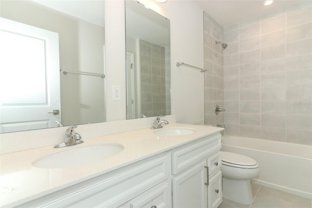 full bathroom with tile patterned flooring, vanity, tiled shower / bath combo, and toilet