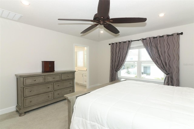 carpeted bedroom with ensuite bathroom and ceiling fan