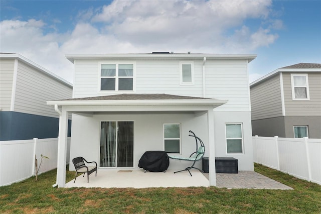 rear view of property featuring a lawn and a patio area