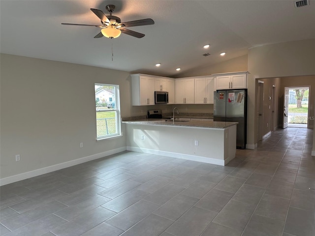 kitchen with white cabinetry, appliances with stainless steel finishes, plenty of natural light, vaulted ceiling, and sink