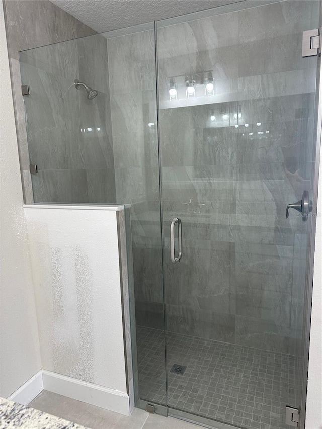 bathroom featuring tile patterned floors and a shower with shower door