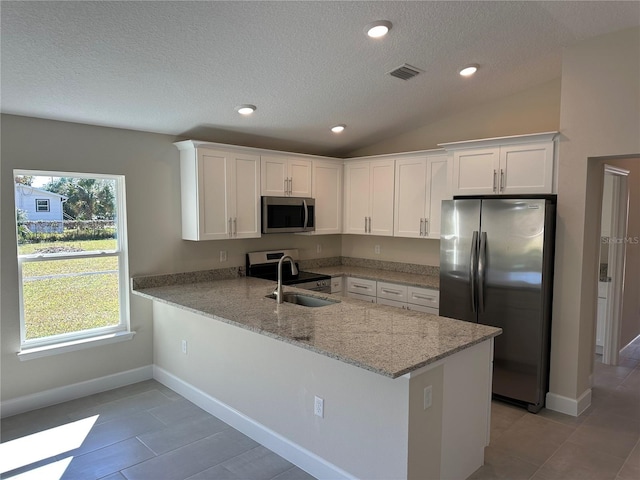 kitchen with sink, kitchen peninsula, appliances with stainless steel finishes, and white cabinets