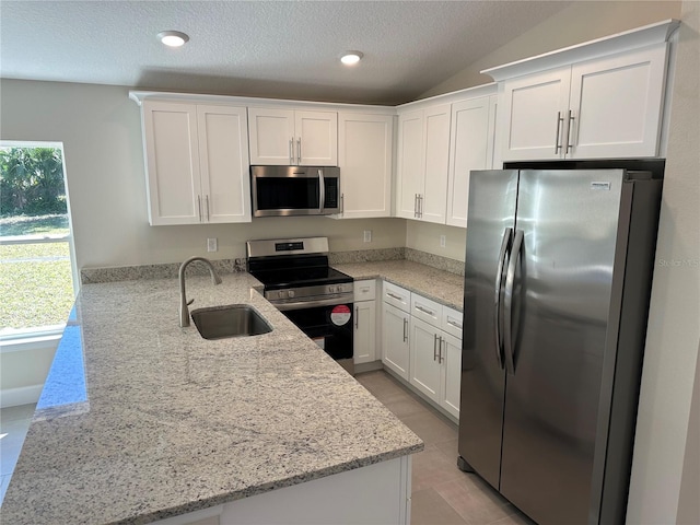 kitchen featuring sink, kitchen peninsula, appliances with stainless steel finishes, and light stone countertops