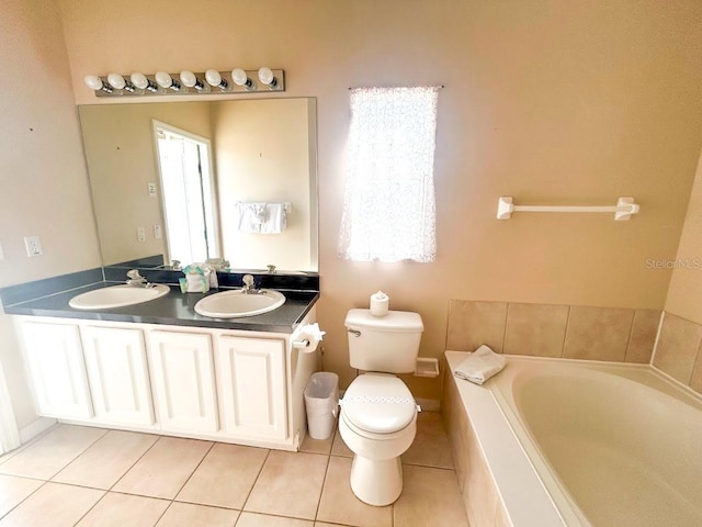 bathroom featuring vanity, tile patterned flooring, toilet, tiled tub, and a healthy amount of sunlight