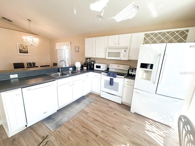 kitchen featuring pendant lighting, white appliances, sink, light hardwood / wood-style flooring, and kitchen peninsula