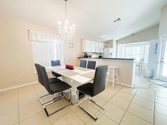 tiled dining space with lofted ceiling and a notable chandelier