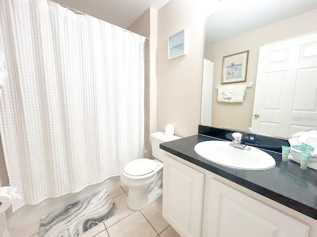 bathroom with tile patterned flooring, vanity, toilet, and walk in shower