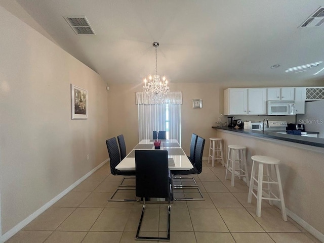 dining space with light tile patterned floors and an inviting chandelier