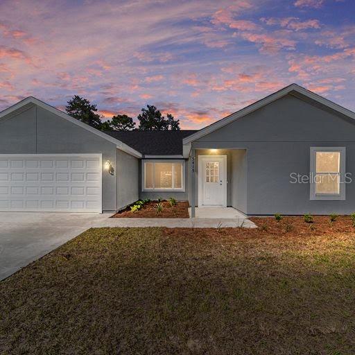 ranch-style house featuring a yard and a garage