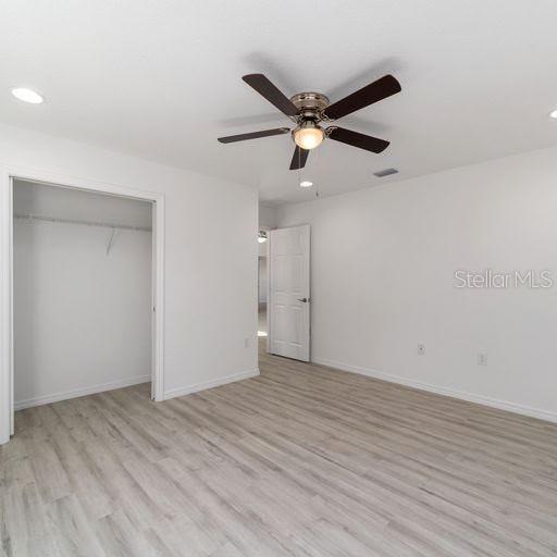 unfurnished bedroom featuring a closet, ceiling fan, and light hardwood / wood-style floors