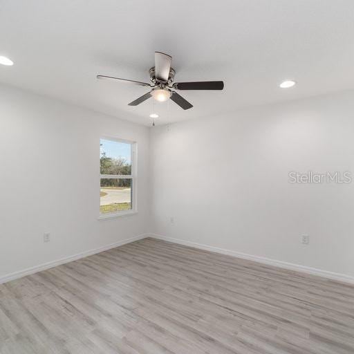 unfurnished room featuring ceiling fan and light wood-type flooring