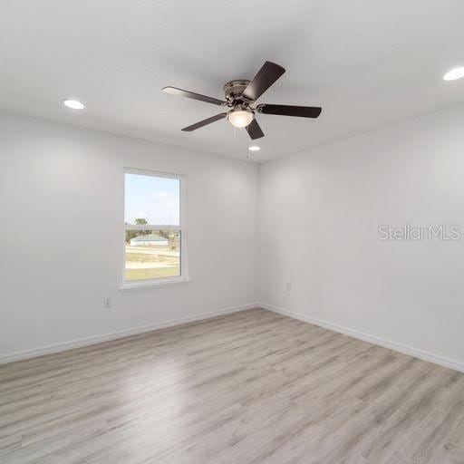 unfurnished room with ceiling fan and light hardwood / wood-style flooring