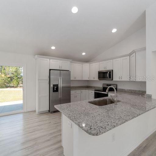 kitchen with white cabinetry, kitchen peninsula, sink, and appliances with stainless steel finishes