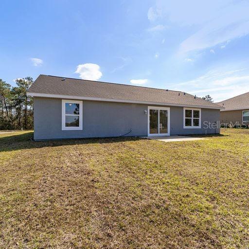 rear view of property with a patio area and a lawn