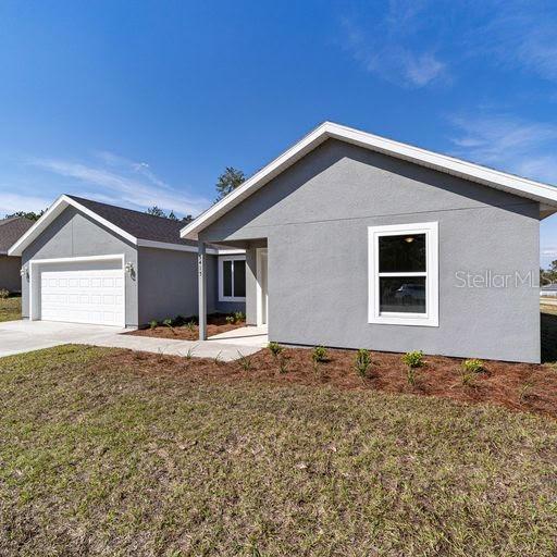 ranch-style house with a garage and a front lawn