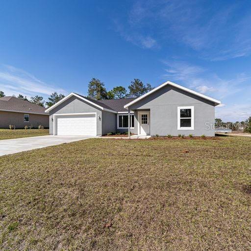 ranch-style house with a garage and a front lawn