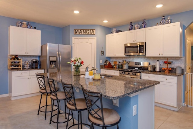 kitchen featuring white cabinetry, a center island with sink, stainless steel appliances, and sink