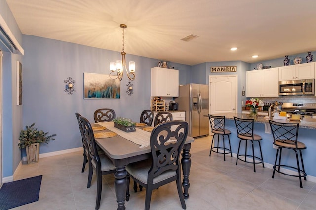 tiled dining room with a notable chandelier