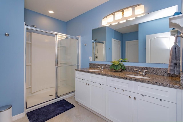 bathroom with tile patterned flooring, vanity, and a shower with shower door