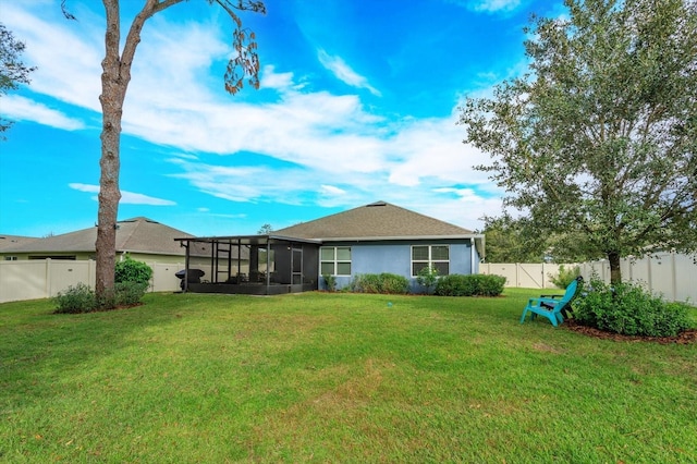 back of property featuring a sunroom and a yard