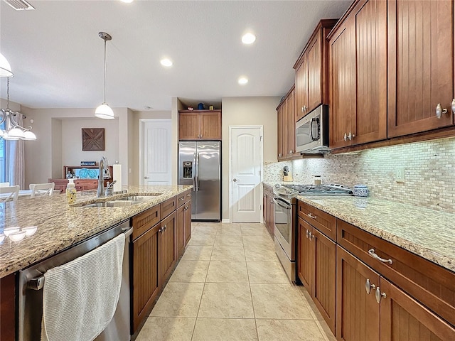 kitchen with backsplash, sink, appliances with stainless steel finishes, decorative light fixtures, and light tile patterned flooring