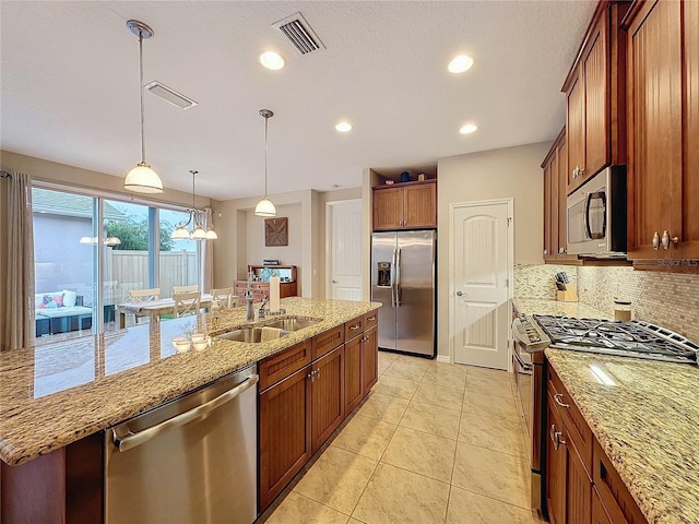 kitchen featuring light stone countertops, sink, hanging light fixtures, stainless steel appliances, and backsplash