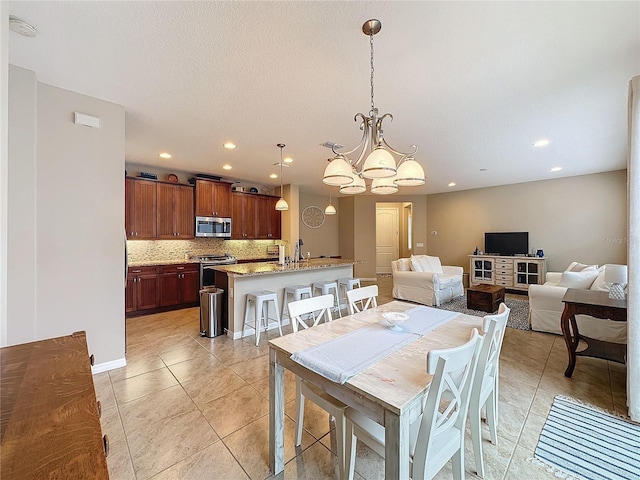 tiled dining area with sink and a chandelier