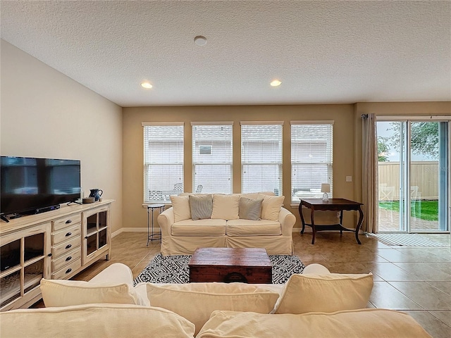 living room with light tile patterned floors, a textured ceiling, and a healthy amount of sunlight