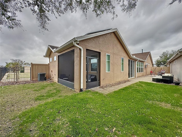 back of property featuring a yard, central AC unit, and a patio area