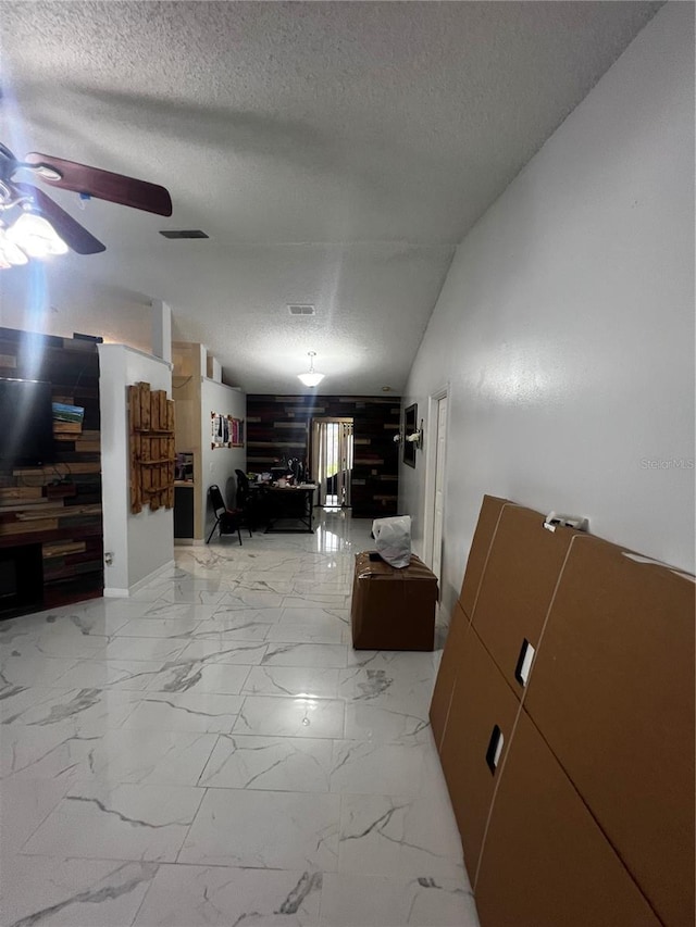 interior space featuring a textured ceiling and vaulted ceiling